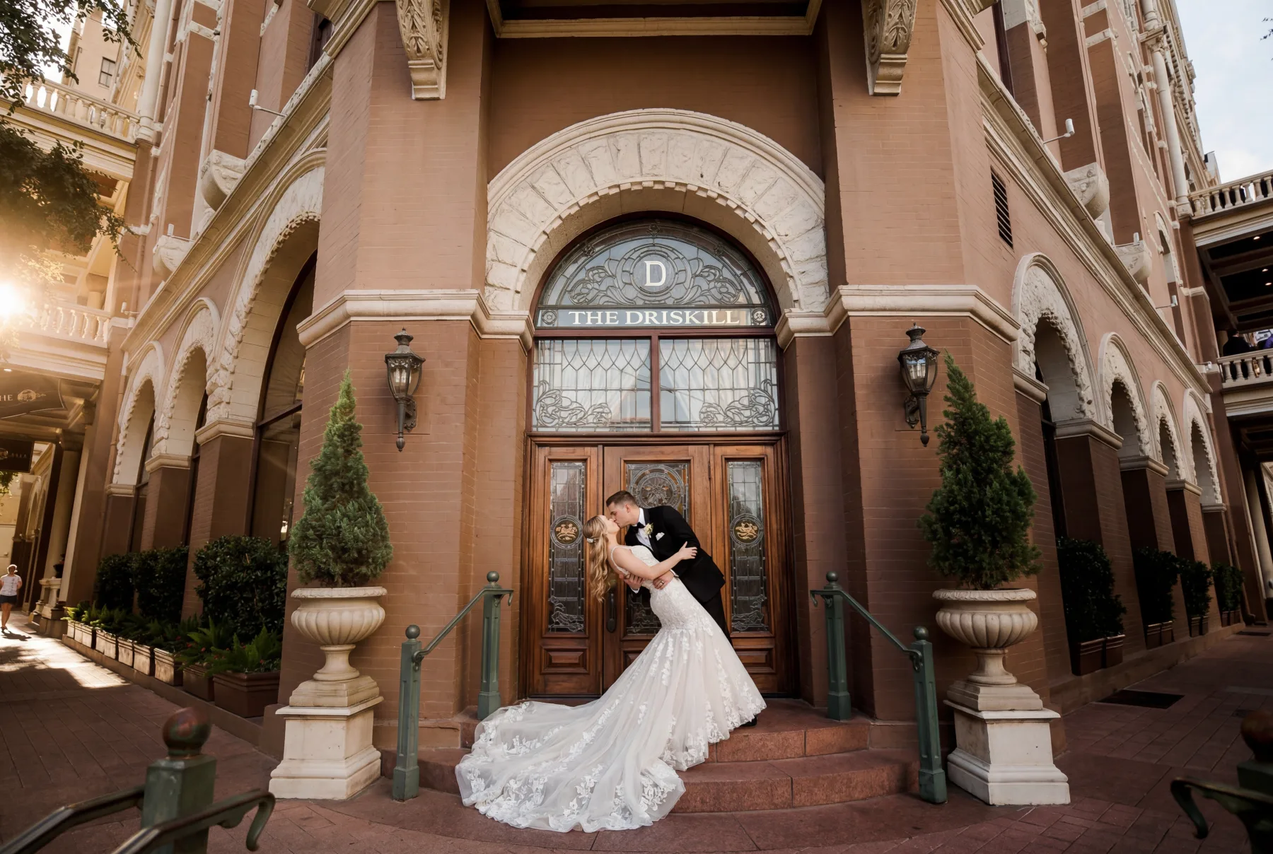 Bride and groom dipping for a kiss outside The Driskill in downtown Austin